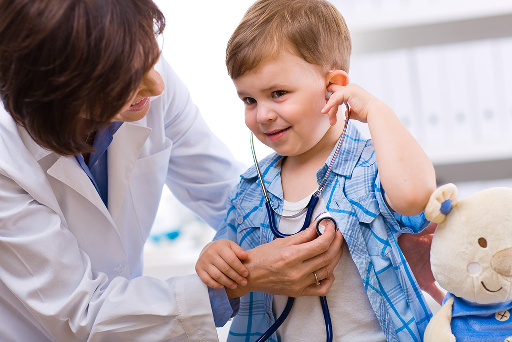 A child being checked with a stethoscope by a doctor