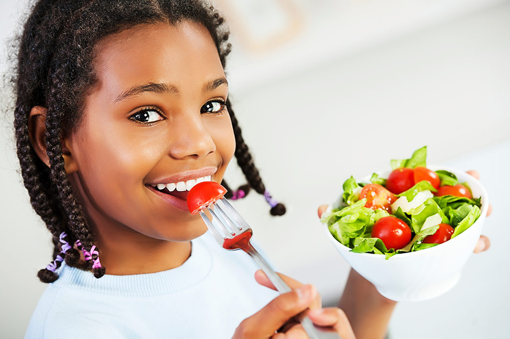 A girl eating healthy food from a bowl